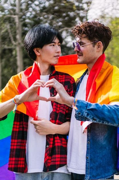 Una Pareja Gay Latina Y China Hacen Una Forma De Coraz N Con Sus Manos Bajo Una Bandera De