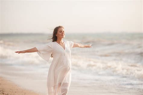 Beautiful Calm Pregnant Woman Wear White Dress Posing Over Sea At