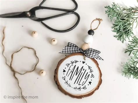 An Ornament With The Word Mom On It Next To Scissors And Other Items