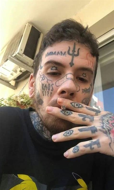 A Man With Tattoos On His Face And Hands