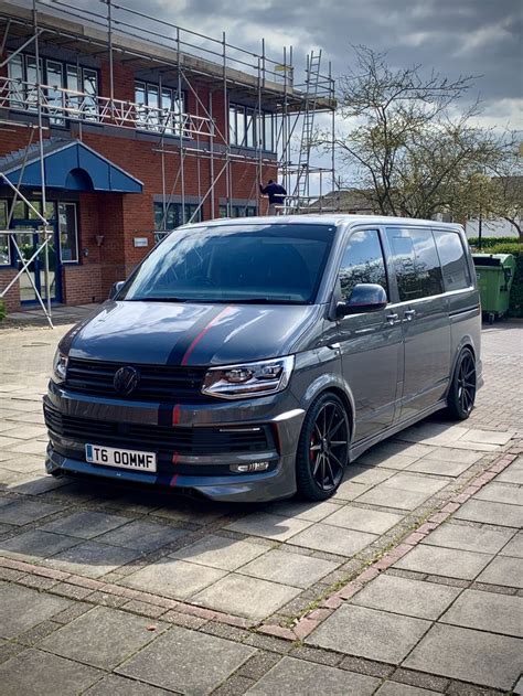 A Grey Van Parked In Front Of A Brick Building