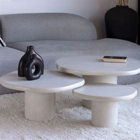 Two Tables Sitting On Top Of A White Rug In Front Of A Couch And Table