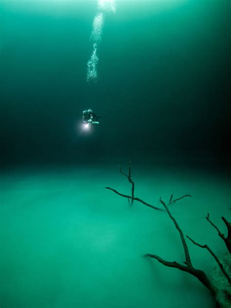 A Diver Approaching An Eerie Scene Deep Underground In A Flooded Cave