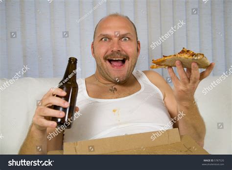 Unhealthy Fat Man Sitting On The Couch Drinking Beer And Eating Pizza