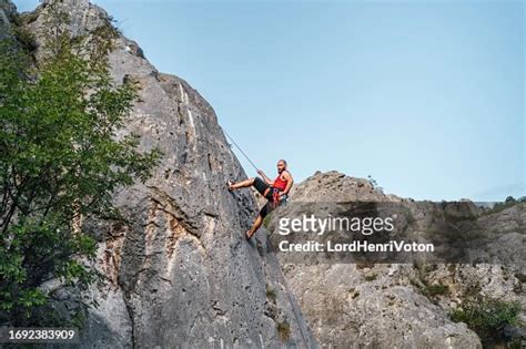 Man Climbing On Vertical Cliff Rock Wall High-Res Stock Photo - Getty ...