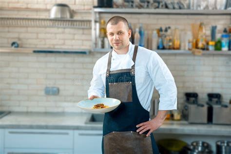 Happy Male Chef Presenting The Dish In Commercial Kitchen Stock Image