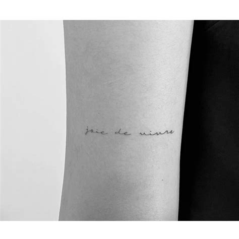 Tattoo that says "joie de vivre" handwritten on the