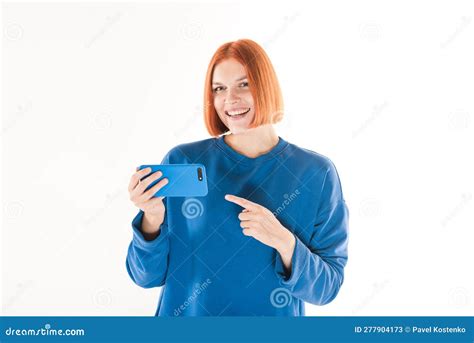 The Girl Uses A Mobile Phone And Points At It With Her Finger On A