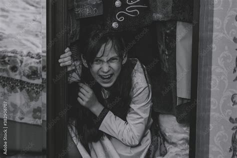 Mad Scary Girl In Cupboard At Dark Night Horror Background With Child