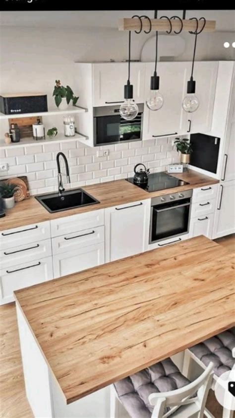 A Kitchen With White Cabinets And Wooden Counter Tops