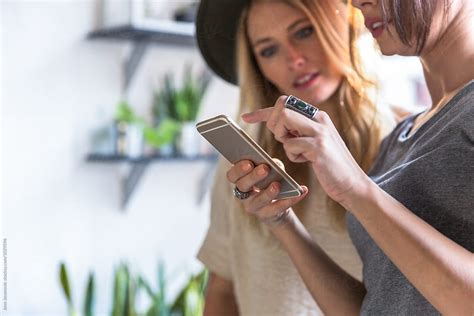 Two Girlfriends Looking At The Phone By Stocksy Contributor Jovo Jovanovic Stocksy