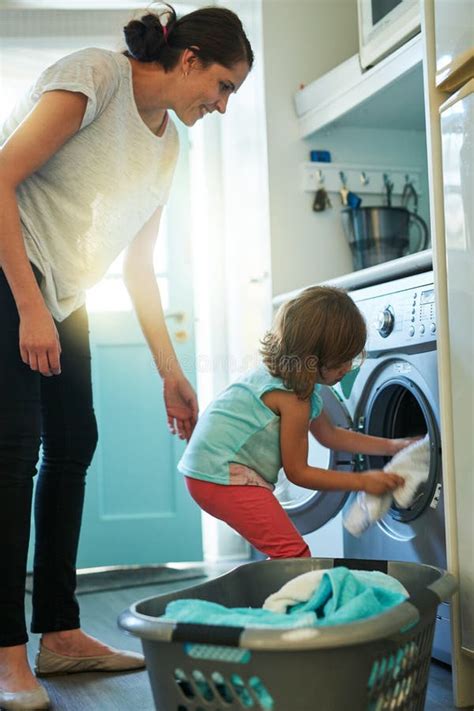 Loading The Washing Machine A Mother And Daughter Using A Washing