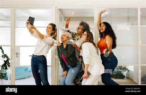 Group Of Cheerful Businesspeople Smiling Happily While Taking A Selfie