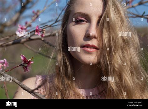 Beautiful Blonde Woman In Pink Flower Garden Stock Photo Alamy