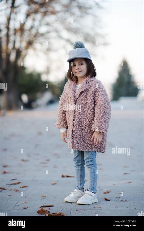 Pretty kid girl 5-6 year old wearing winter coat and stylish hat posing ...