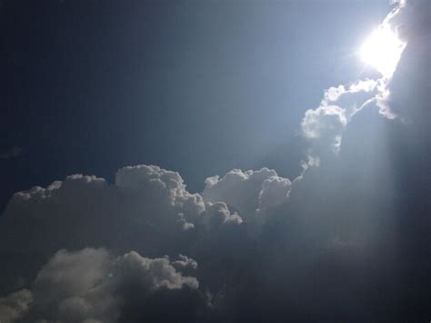 Premium Photo Low Angle View Of Sun Shining Through Clouds