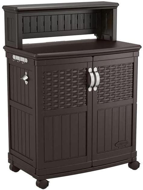 an outdoor storage cabinet with doors and drawers on wheels, in dark ...