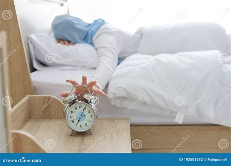 Oversleeping Asian Muslim Woman Wearing White Sleepwear Lying On Bed