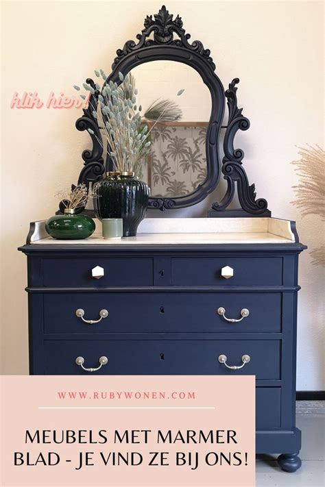 A Blue Dresser With A Mirror And Vase On Top