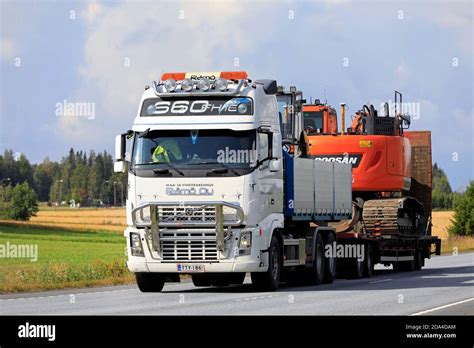 White Volvo FH16 Truck Hauls Doosan Tracked Excavator On Trailer Along