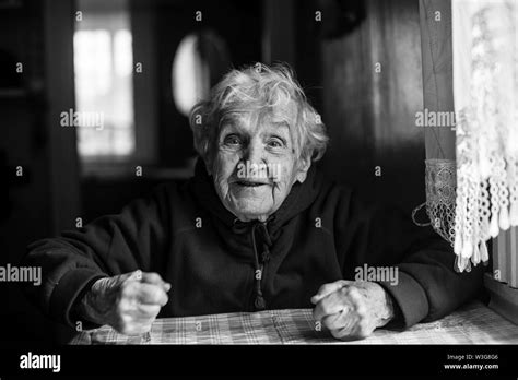 Portrait Of An Emotional Old Woman In Her House Black And White Photo