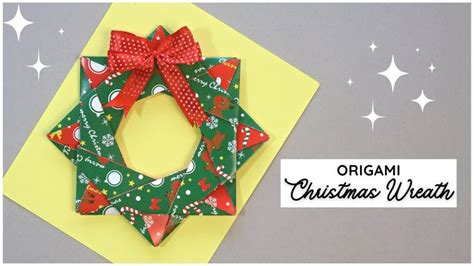 An Origami Christmas Wreath On Top Of A Yellow Card With Red Ribbon And