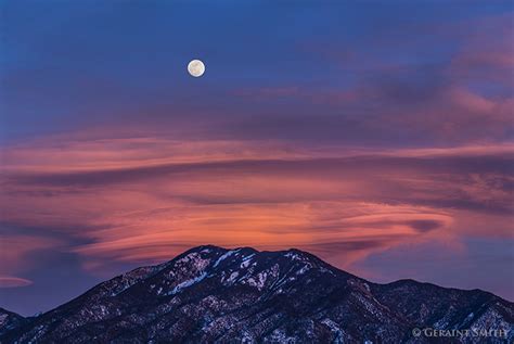 Snow Moon and lenticular clouds over Taos Mountain, NM