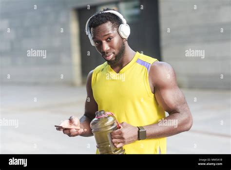 Strong African Man Drinking Water After Hard Workout Looking At Camera