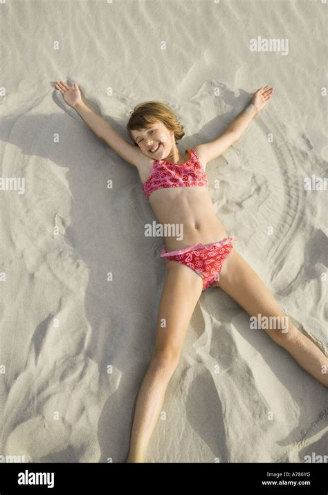 Girl Making Angel In Sand On Beach High Angle View Stock Photo