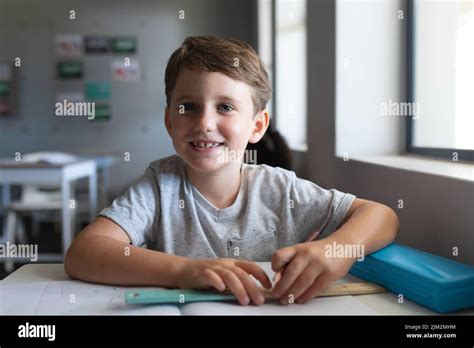 Portrait d un jeune garçon élémentaire caucasien souriant avec un livre