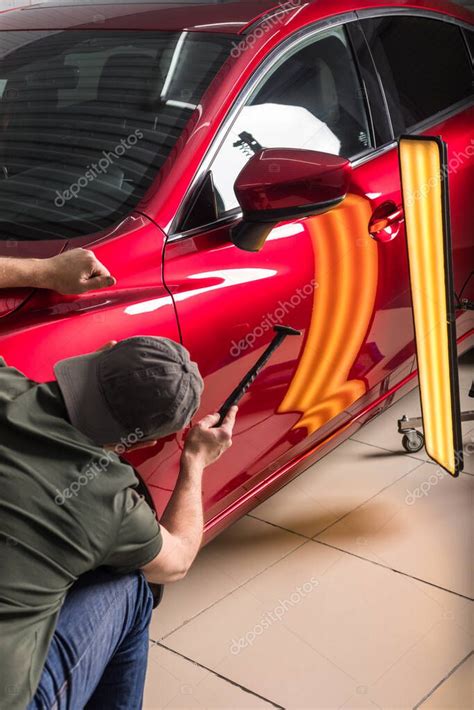 El técnico elimina abolladuras en el coche utilizando el método sin