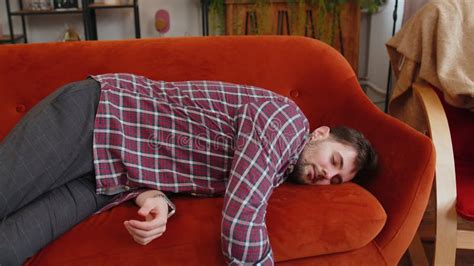 Exhausted Young Alcoholic Drunk Man Flopped Down On Couch Falls Asleep After Party Tired