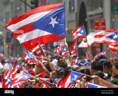 Puerto Rican flags wave as spectators line Fifth Avenue during the Puerto Rican Day Parade ...