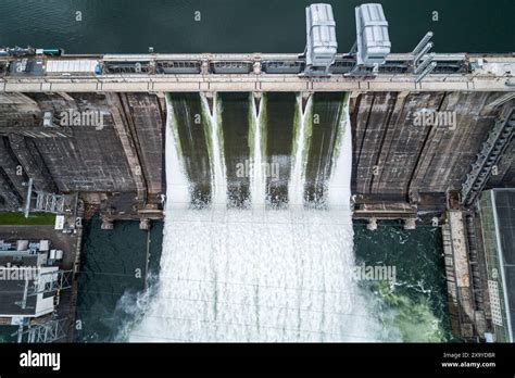 Aerial Top Down View Of Concrete Dam Releasing Water Into River On