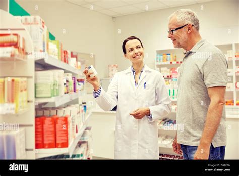 Pharmacist Showing Drug To Senior Man At Pharmacy Stock Photo Alamy