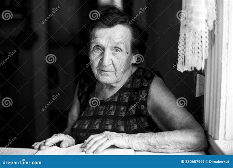 An Old Woman Sits In Her House Black And White Photo Stock Image