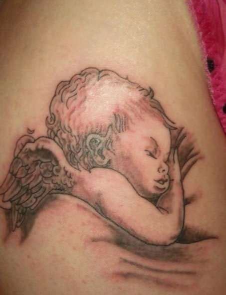 An Angel Tattoo On The Back Of A Woman S Thigh With Her Arm Wrapped Around