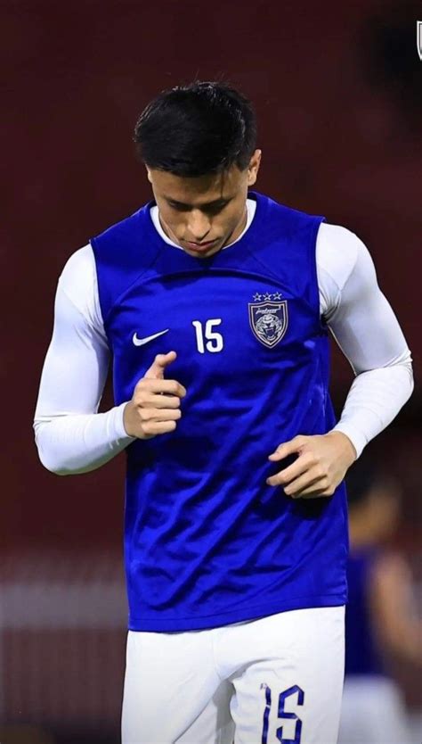 The Soccer Player Is Looking Down At His Shirt While Holding His Hand