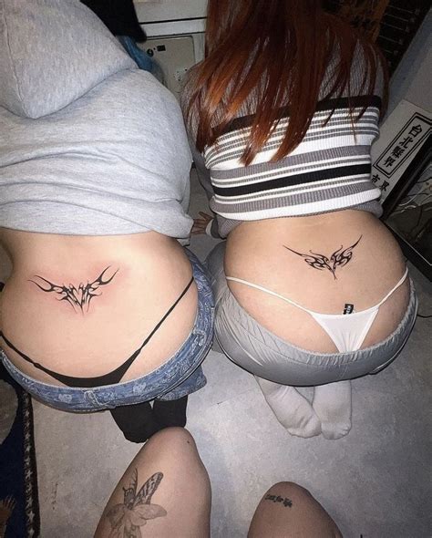 Two Women With Tattoos On Their Butts