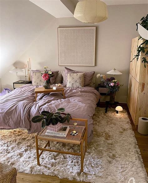 A Bedroom With A Bed Nightstands And Plants On The Floor In Front Of It