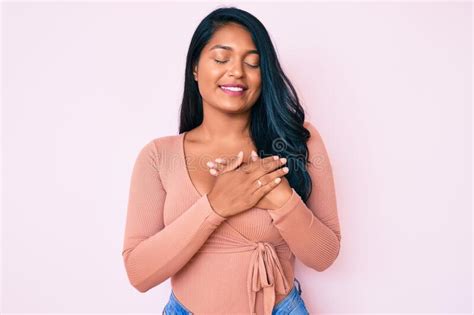 Bella Joven Latina De Cabello Largo Con Ropa Casual Sonriendo Con Las Manos En El Pecho Con Los