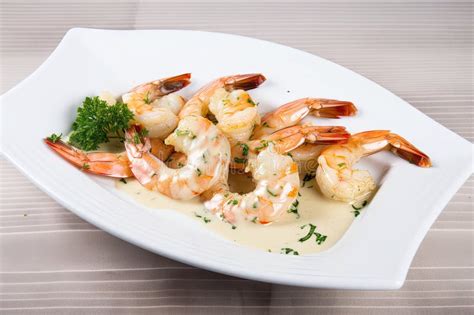 Plate Of Tiger Shrimp Prawns Drizzled With Creamy Garlic Sauce Stock