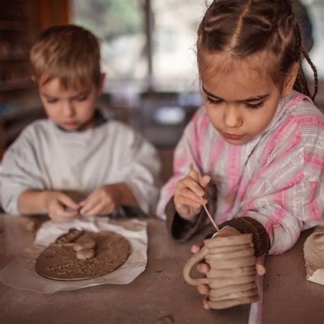 Crianças lindas brincando argila de modelagem na oficina de