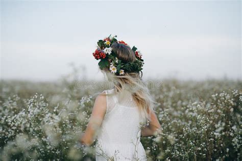 Portrait D Une Fille Assez Blonde Avec Des Yeux Bleus Avec Une Guirlande Des Fleurs Sur Son Chef