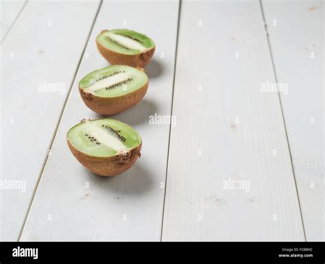 Three Sliced Halves Of Kiwifruit Or Chinese Gooseberry Kiwi Over The