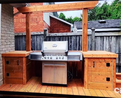 An Outdoor Bbq With Grill And Cabinets On The Outside Decking Area In