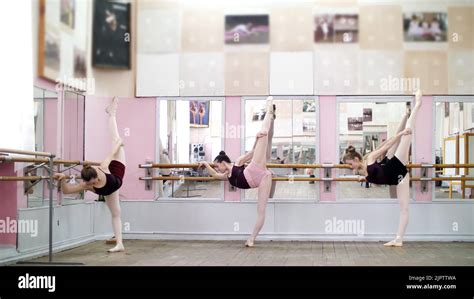 In Dancing Hall Young Ballerinas In Black Leotards Are Stretching