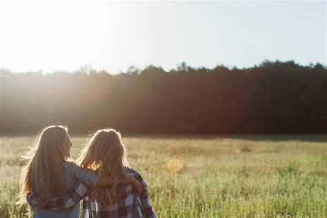 Norfolk And Suffolk Victim Care Two Female Friends With Arms Around Each Other Sitting In A Field