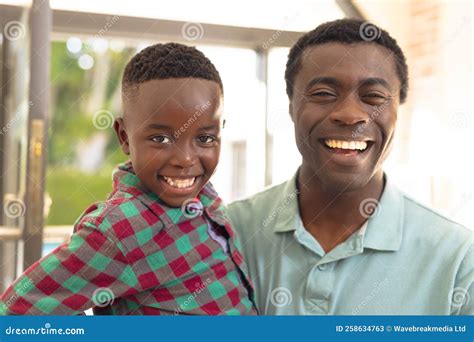 African American Father And Son Welcoming Some Body Outside The House