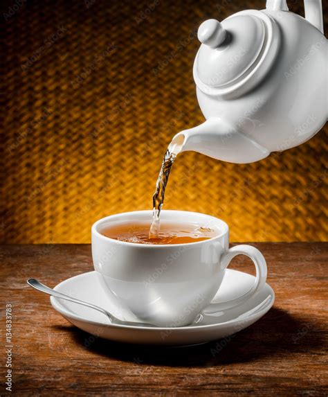 Tea Being Poured Into Tea Cup Stock Photo Adobe Stock